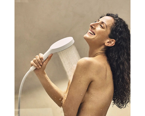 Frau benutzt eine Handbrause unter der Dusche