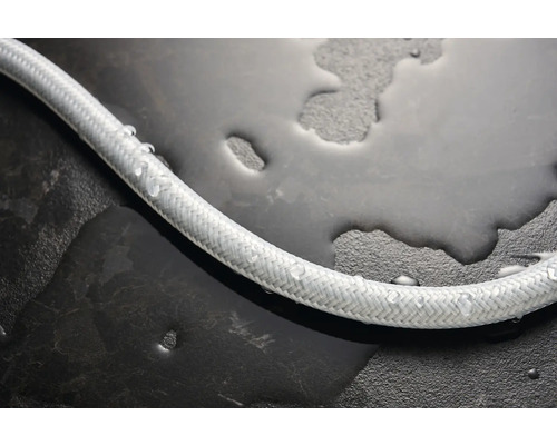 Flexibler Wasserschlauch mit Textilummantelung auf feuchtem Untergrund