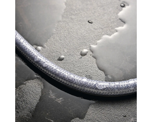 Flexibler Duschschlauch auf feuchtem Untergrund.