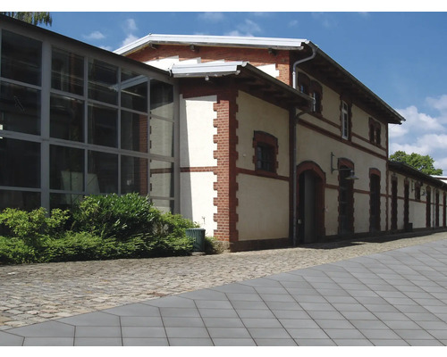 Außenansicht eines mehrstöckigen Gebäudes mit Ziegeldetails und großen Fenstern