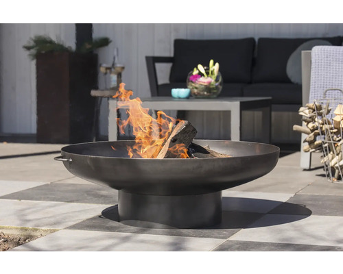 Feuerschale aus Metall mit Holz und Flammen im Gartenbereich
