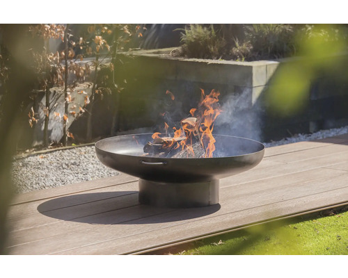 Feuerstelle mit brennendem Holz auf einer Terrasse