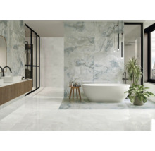 Helles Badezimmer mit Badewanne, Waschtisch und großformatigen Fliesen in Marmoroptik.