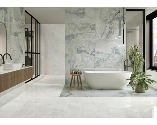 Helles Badezimmer mit Badewanne, Waschtisch und großformatigen Fliesen in Marmoroptik.