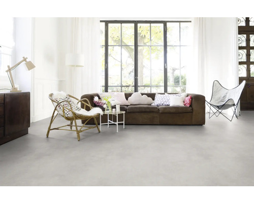 Helles Wohnzimmer mit Sofa, Sessel und großem Fenster