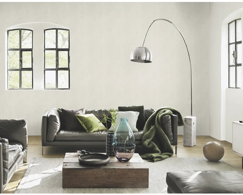 Wohnzimmer mit Ledersofa, Holztisch, Stehlampe und großen Fenstern für eine helle Atmosphäre.