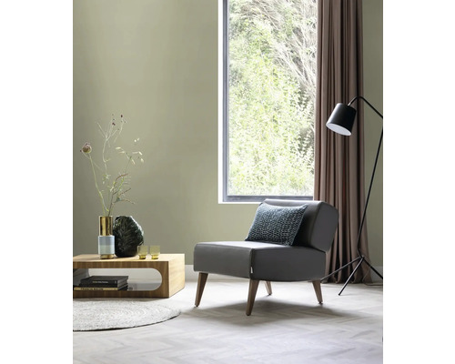 Wohnzimmer mit Sessel, Couchtisch, Stehlampe und Fenster für eine helle Atmosphäre