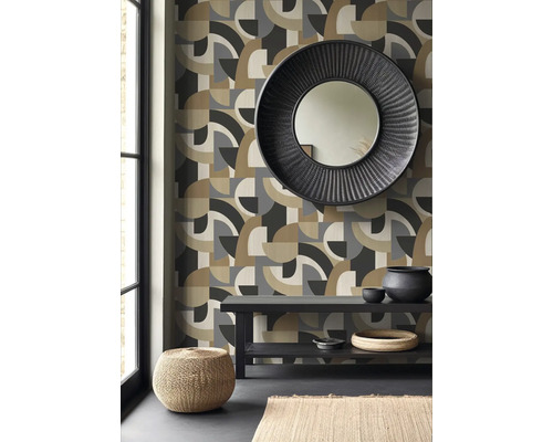 Wohnraum mit geometrischer Tapete, rundem Spiegel und Dekorationen auf einem Tisch