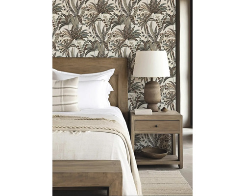 Schlafzimmer mit gemusterten Tapeten, Holzbett und Nachttisch mit Lampe