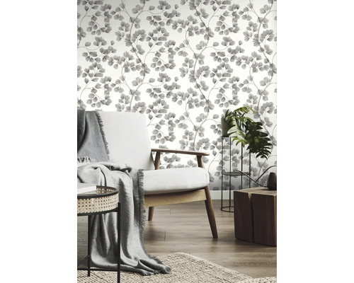 Wohnzimmer mit gemusterter Tapete, Sessel und Zimmerpflanzen