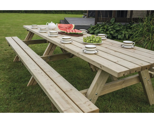 Picknicktisch aus Holz mit Speisen und Getränken im Garten
