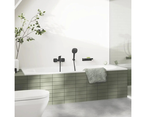 Badezimmer mit Badewanne, Armatur, Handbrause, Ablage und Handtuch