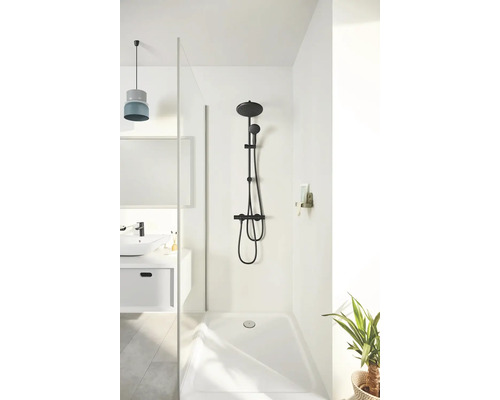 Duschbereich mit schwarzer Duscharmatur, Duschkopf und Handbrause vor weißer Wand