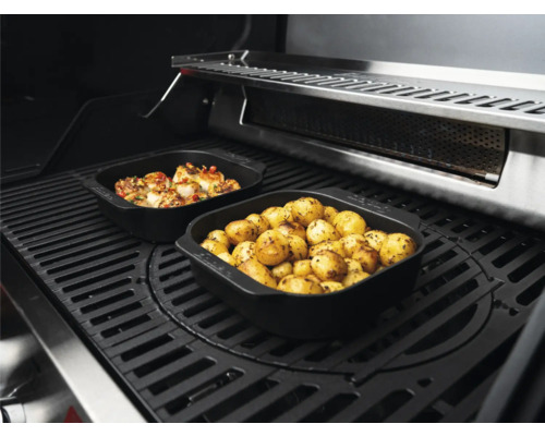 Zwei mit Kartoffeln und Fleisch gefüllte Grillpfannen auf dem Grillrost