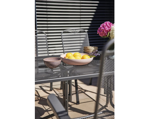 Gartenszene mit Tisch, Stühlen, Zitronenschale und Blumen