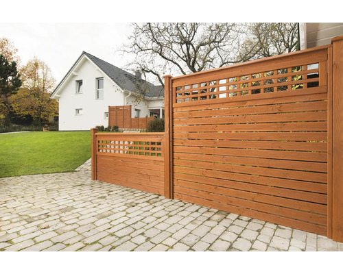 Holzzaun mit horizontalen Brettern und quadratischem Gittermuster vor einem Haus
