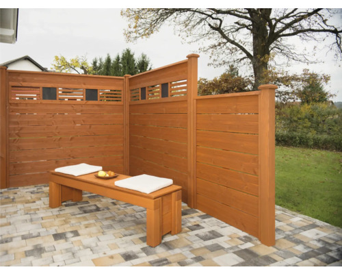 Holzsichtschutzwand mit Holzbank und Kissen im Garten