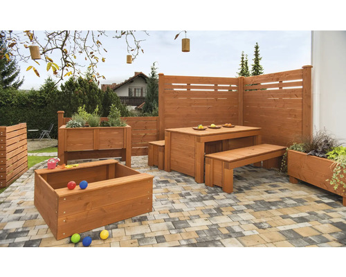 Terrasse mit Holztisch, Bänken, Sichtschutzzaun, Hochbeet und Sandkiste