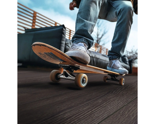 Person auf einem Skateboard auf einer Terrasse mit Holzboden