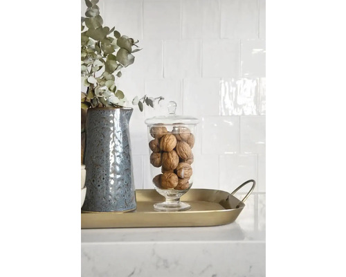 Dekorative Anordnung mit Krug, Eukalyptus, Glasgefäß und Walnüssen auf einem goldenen Tablett