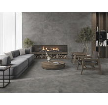 Helles Wohnzimmer mit grauen Fliesen, Sofa, Sessel und Kamin