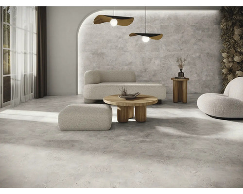 Heller Raum mit Betonboden, Sofa, Sessel und Holztisch