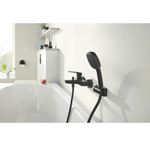 Badezimmer mit schwarzer Armatur und Handbrause an der Wand über der Badewanne.