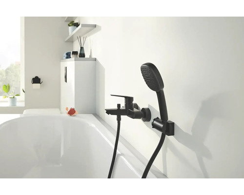 Badezimmer mit schwarzer Armatur und Handbrause an der Wand über der Badewanne.