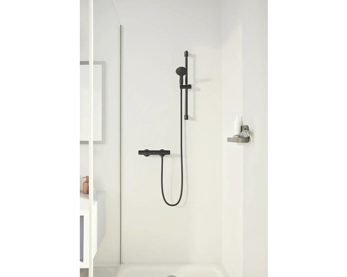 Duscharmatur mit Brausestange und Ablage im Badezimmer.