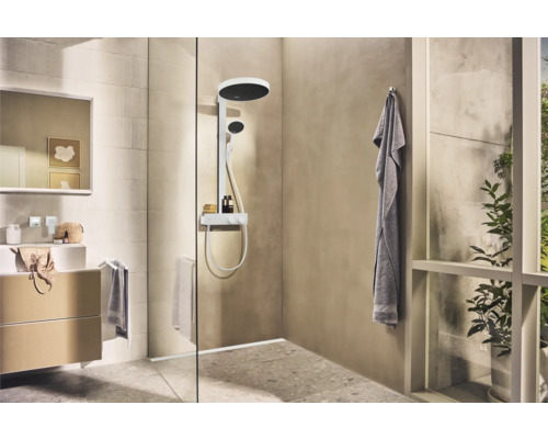 Badezimmer mit Dusche, Waschtisch und Spiegel für ein helles und geräumiges Ambiente.