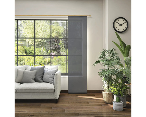 Wohnzimmer mit Schiebegardine am Fenster, Sofa und Zimmerpflanzen