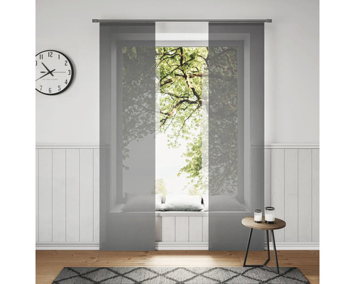 Wohnzimmer mit Schiebegardinen am Fenster, Uhr und Teppich