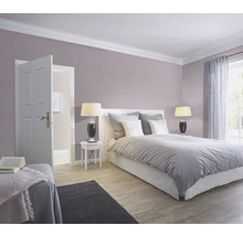 Schlafzimmer mit Bett, Nachttischen, Lampen und geöffneter Tür