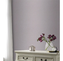 Dekoratives Zimmer mit Mustertapete an der Wand, Kommode, Blumenvase und Vorhang am Fenster.