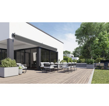 Terrasse mit Markise, Esstisch und Stühlen vor einem Wohnhaus