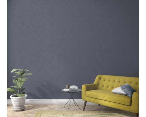 Wohnzimmer mit gelbem Sofa, Pflanze, Tisch und Teppich für eine gemütliche Atmosphäre