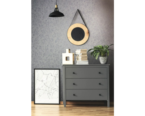 Szene mit grauer Kommode, darauf Dekoartikel, darunter ein gerahmtes Bild, darüber eine Lampe und ein Spiegel an der Wand