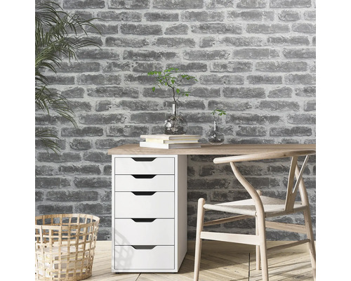 Arbeitszimmer mit Schreibtisch, Stuhl und Backsteinmauer