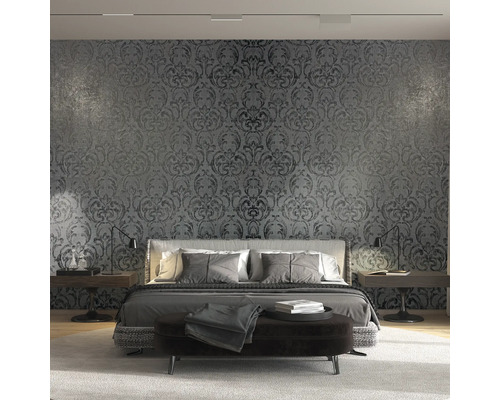 Schlafzimmer mit floral gemusterter Tapete hinter dem Bett