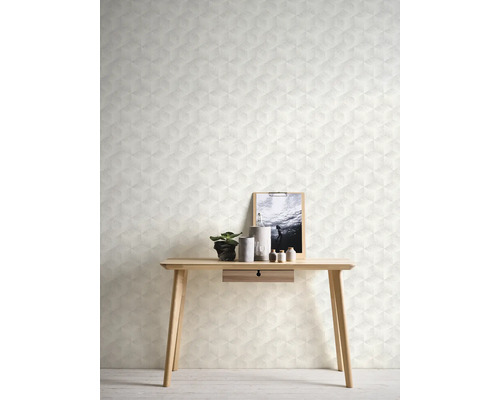 Nahaufnahme einer Wand mit geometrischer Tapete, einem Holztisch, Dekoartikeln und einem Bilderrahmen.