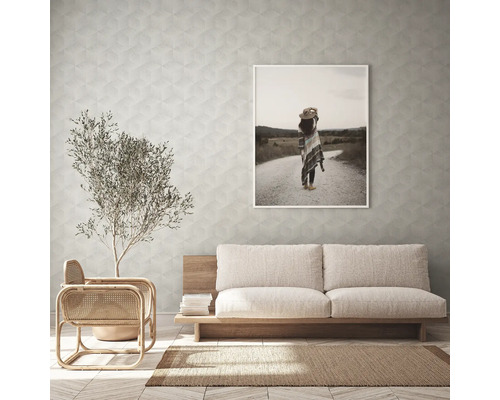 Wohnzimmer mit Sofa, Sessel, Zimmerpflanze, Teppich und gerahmtem Bild an der Wand