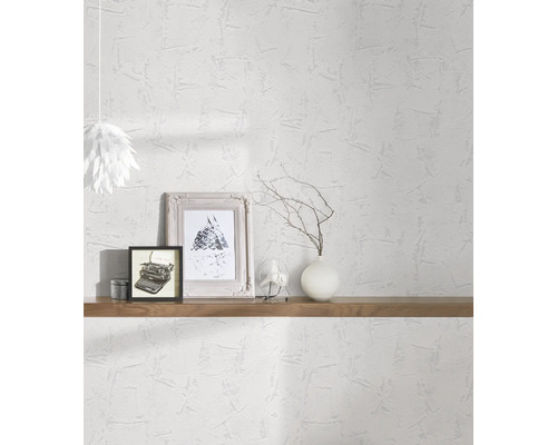 Helles Zimmer mit weißer Struktur Tapete, dekoriert mit Regalen, Bildern und einer Lampe.