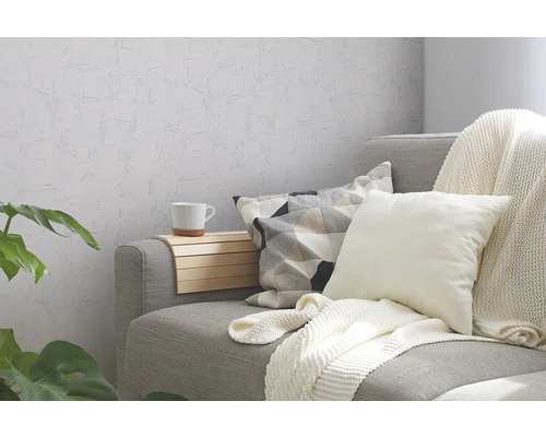 Graues Sofa mit Kissen, Decke und Beistelltisch im Wohnzimmer