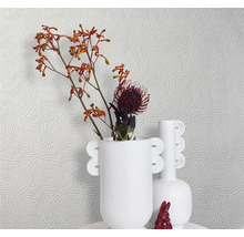Helle Tapete mit Wellenmuster, dazu weiße Vasen und Blumen