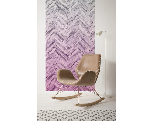 Wohnraumszene mit Raufasertapete in Fischgrätmuster, Schaukelstuhl, Stehlampe und Teppich