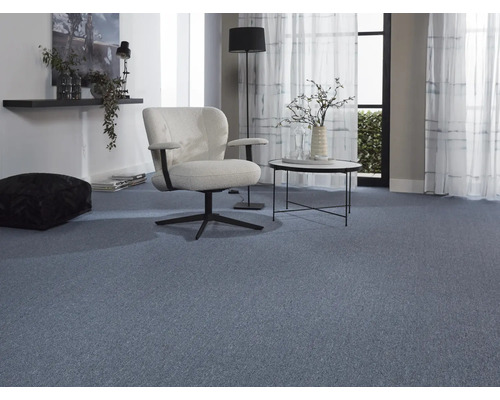 Wohnzimmer mit blauem Teppichboden, Sessel und Beistelltisch