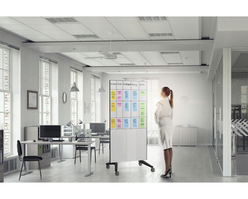 Helles Büro mit Schreibtischen, Bürostühlen und einer rollbaren Whiteboard Tafel mit Notizen