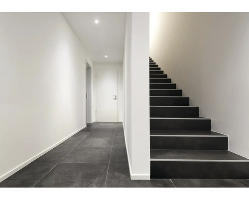 Heller Flur mit Treppe und Fliesenboden