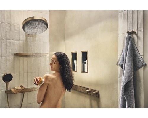 Helles Badezimmer mit Dusche, Handtuch und einer Frau, die eine Bürste benutzt.