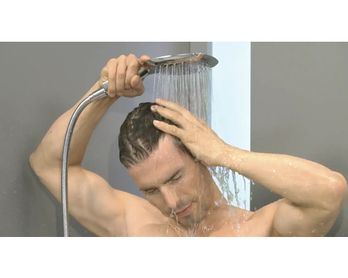 Mann duscht sich mit einer Handbrause im Badezimmer